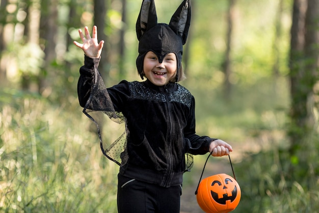 Medium shot of little boy in bat costume