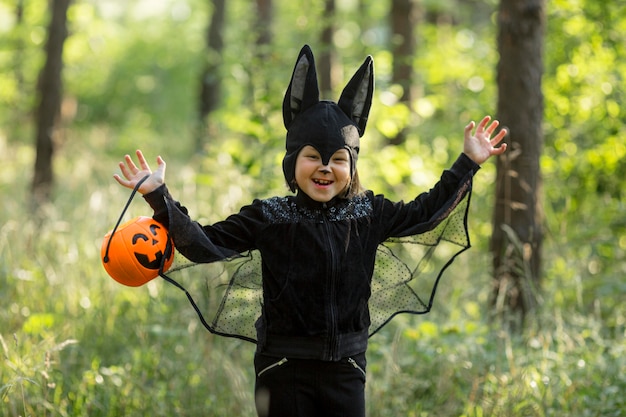 Medium shot of little boy in bat costume