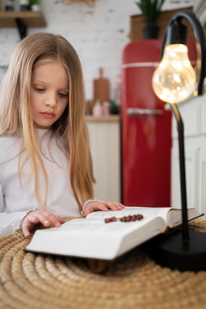 중간 샷 성경을 읽는 어린 소녀