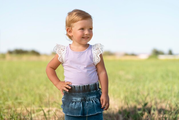 Medium shot of a little girl smiling and looking away