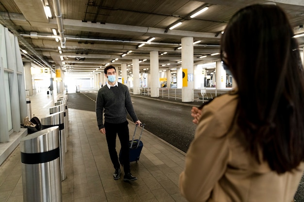 Foto gratuita riunione di coppia a distanza di campo medio all'aeroporto