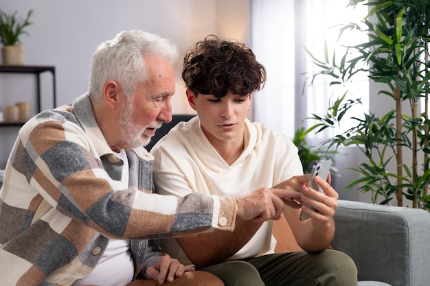 Free photo medium shot man and boy with smartphone