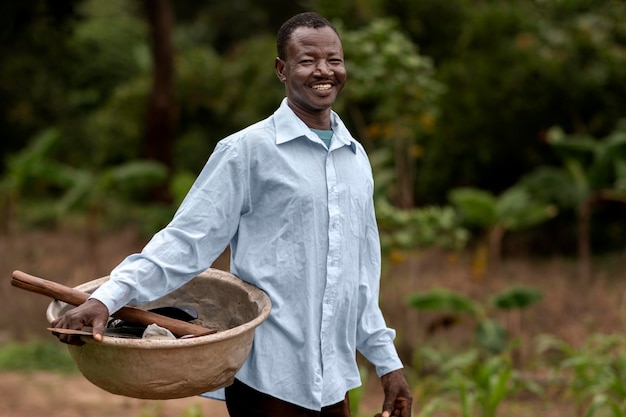 Free photo medium shot man carrying pot