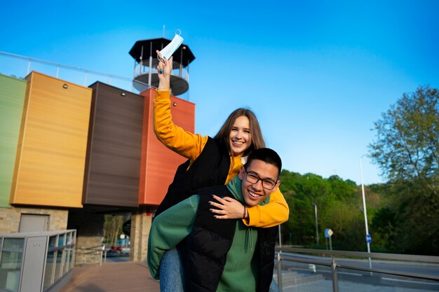 Medium shot man carrying smiley woman