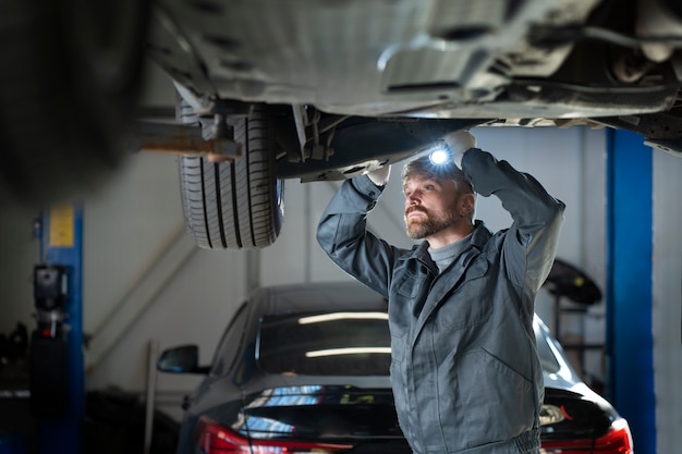 無料写真 車をチェックするミディアムショットの男