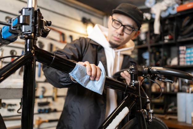 Free photo medium shot man cleaning bicycle