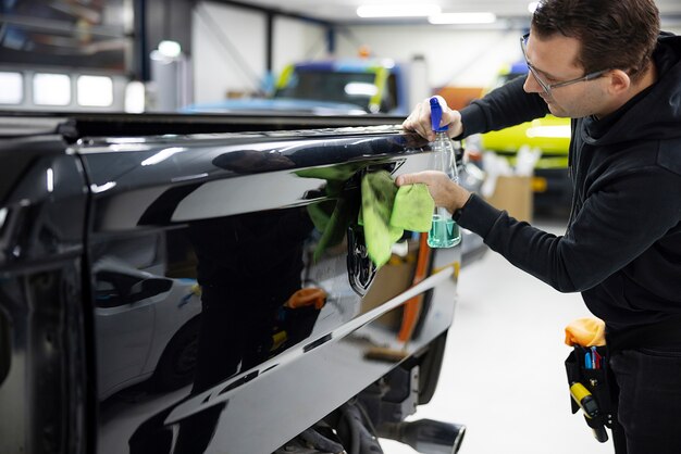 Medium shot man cleaning car