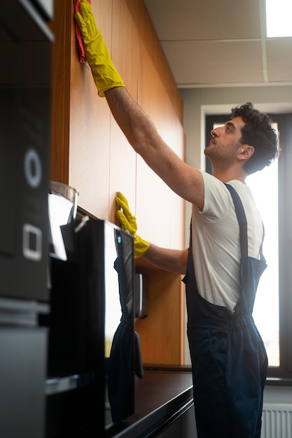 Free photo medium shot man cleaning indoors