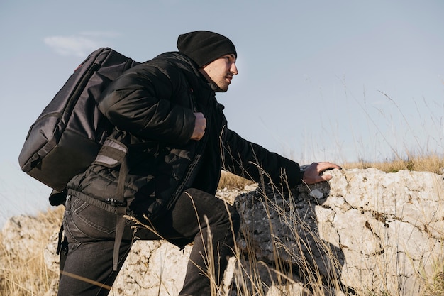 Medium shot man climbing rocks