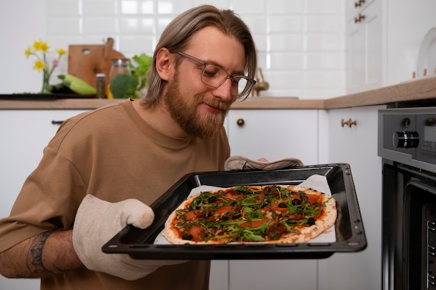 Free photo medium shot man cooking pizza