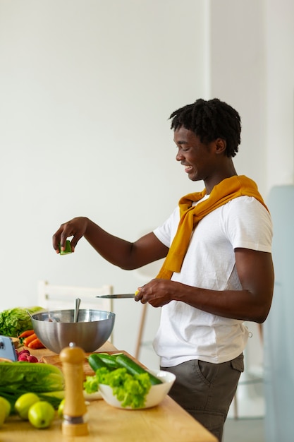 Foto gratuita uomo di tiro medio che cucina con lo smartphone