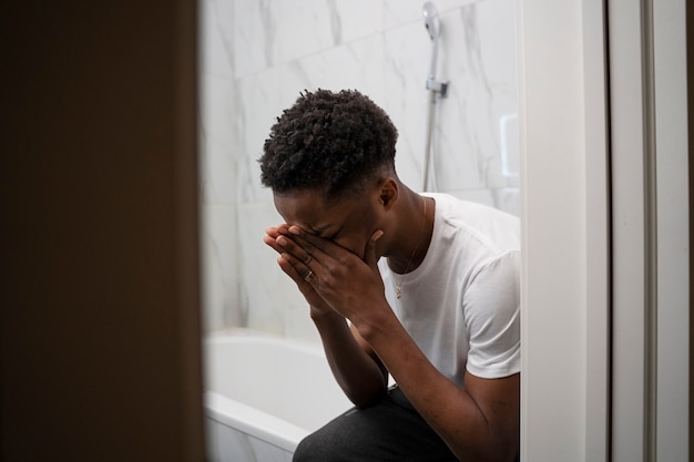 Medium shot man crying in bathroom