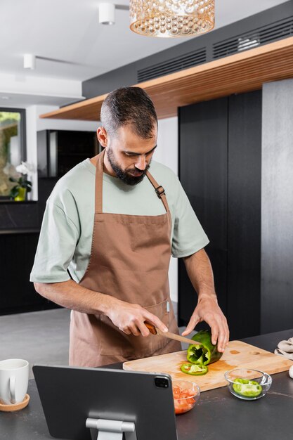 Medium shot man cutting vegetable