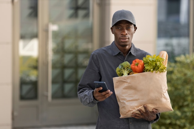 Бесплатное фото Мужчина среднего роста доставляет продукты