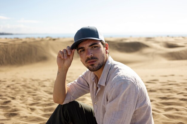 Medium shot man in desert with trucker hat