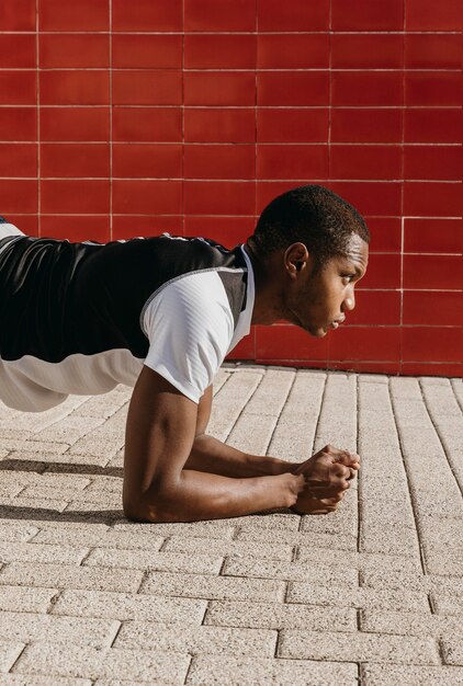 Medium shot man doing plank