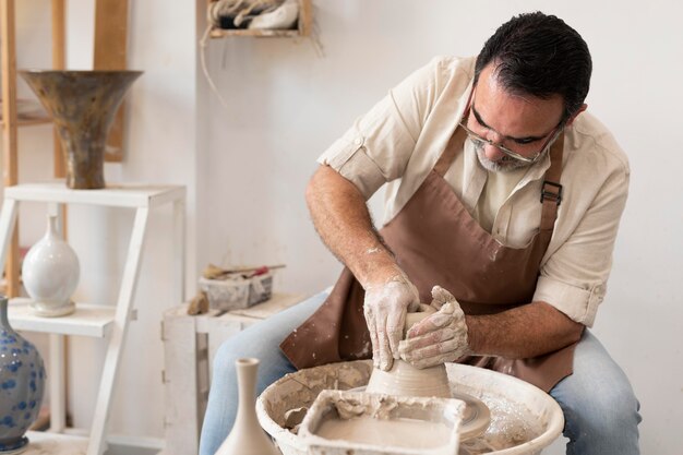 Medium shot man doing pottery