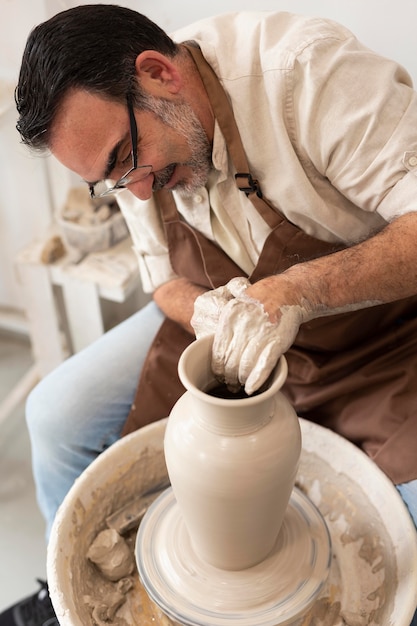 Foto gratuita uomo di tiro medio che fa la ceramica