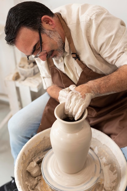 Free photo medium shot man doing pottery