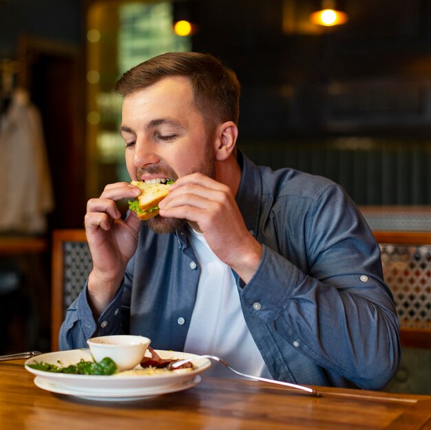 Medium shot man eating indoors