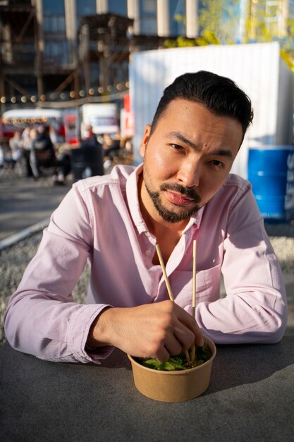 Medium shot man eating salmon bowl