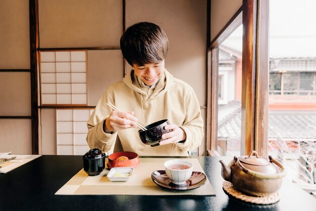 箸で食べるミディアムショットの男