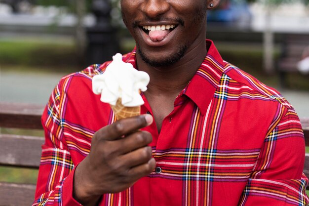Средний снимок человека, наслаждающегося мороженым