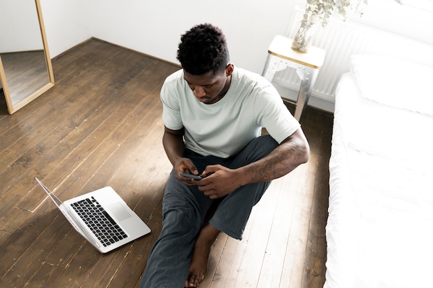 Medium shot man on floor with devices