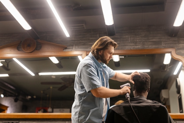 Foto gratuita uomo del colpo medio che ottiene un taglio di capelli