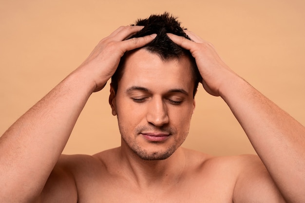 Medium shot man giving himself scalp massage