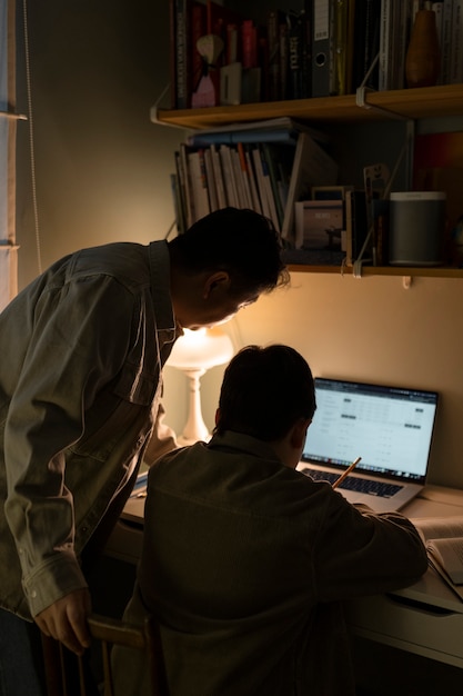 Free photo medium shot man helping kid with homework