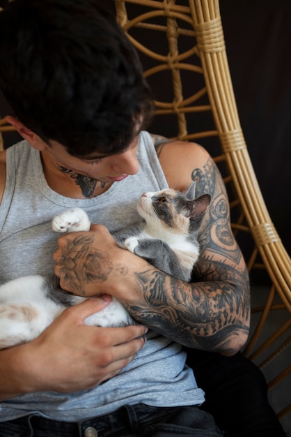 Free photo medium shot man holding adorable cat