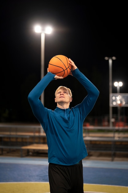 Foto gratuita uomo del tiro medio con palla da basket