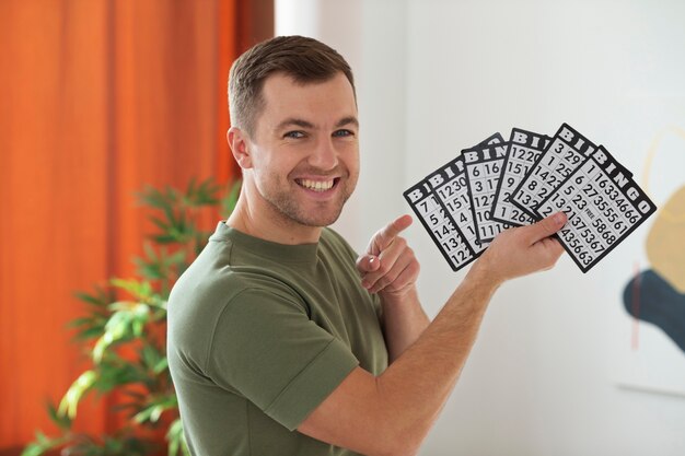 Medium shot man holding bingo cards