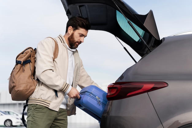 Medium shot man holding blue baggage