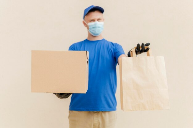 Medium shot man holding box and bag