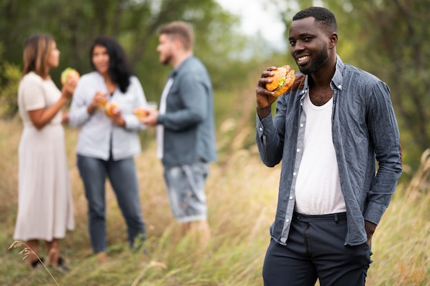 Foto gratuita hamburger della holding dell'uomo del colpo medio