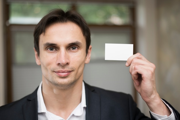 Medium shot of man holding business card