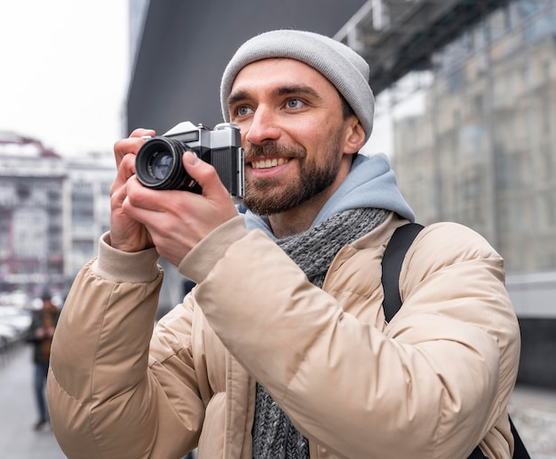 Free photo medium shot man holding camera