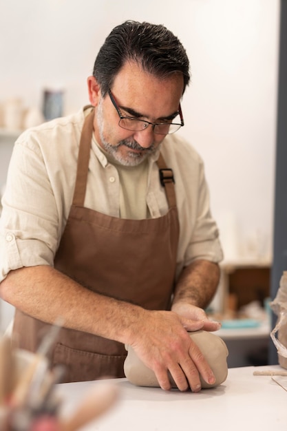 Medium shot man holding clay