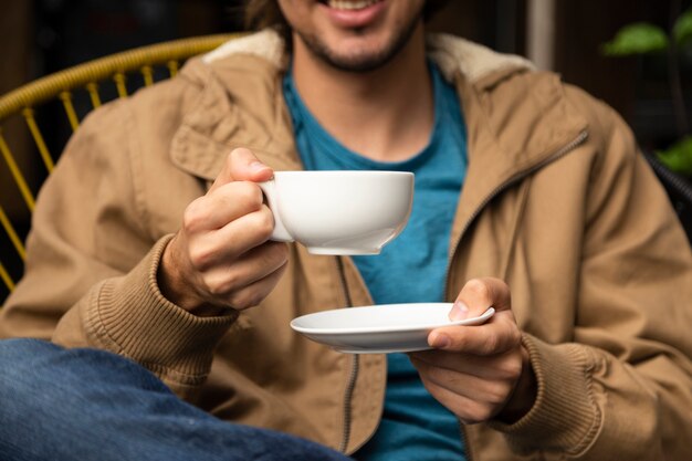 Medium shot of man holding coffee cup