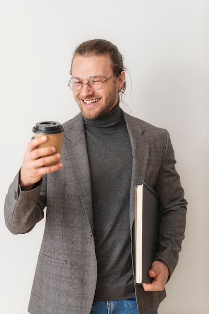 Мужчина среднего роста держит чашку кофе