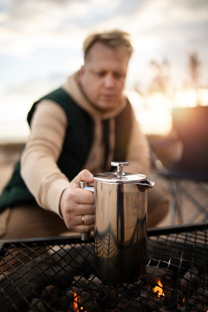 Free photo medium shot man holding coffee pot