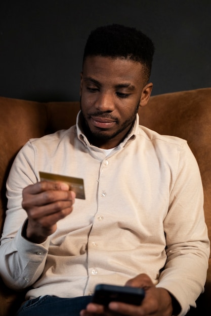 Free photo medium shot man holding credit card