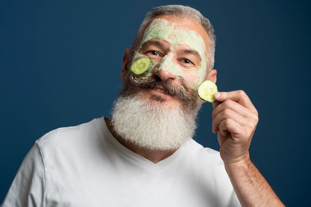 Medium shot man holding cucumber slice