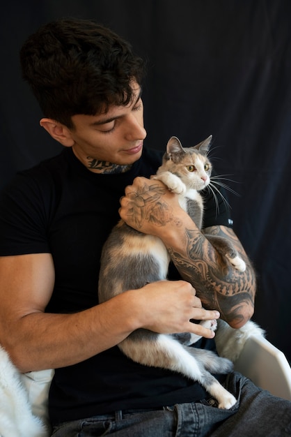 Мужчина среднего роста держит симпатичную кошку