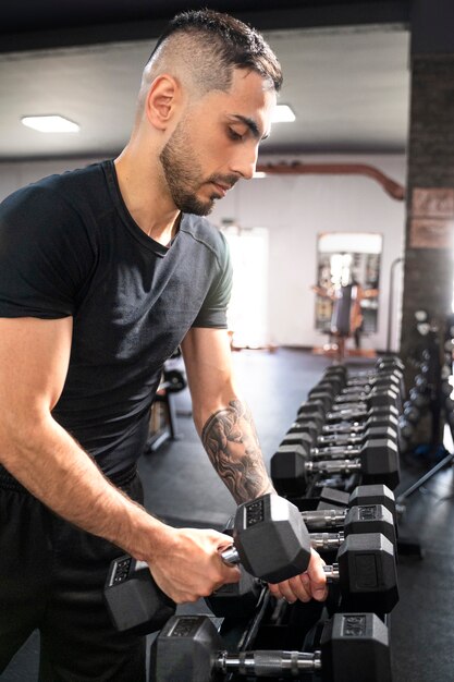 Medium shot man holding dumbbells