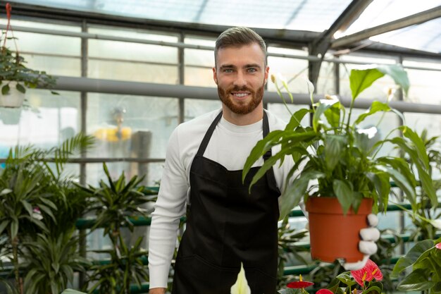 Medium shot man holding flower pot