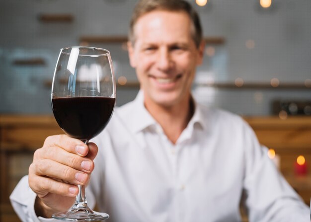 Medium shot of man holding glass of wine