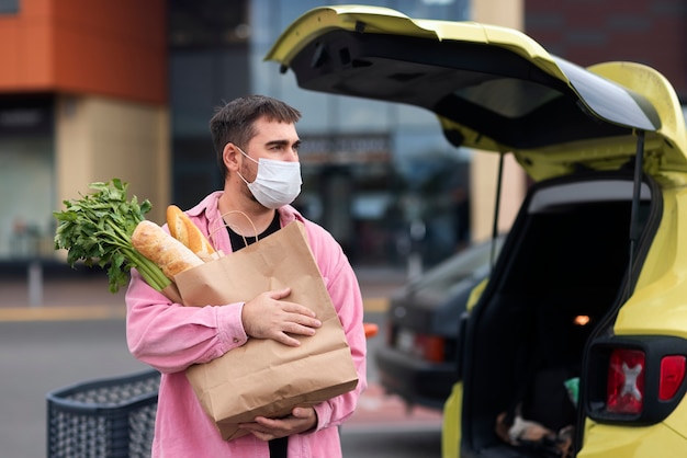 Foto gratuita uomo del colpo medio che tiene generi alimentari